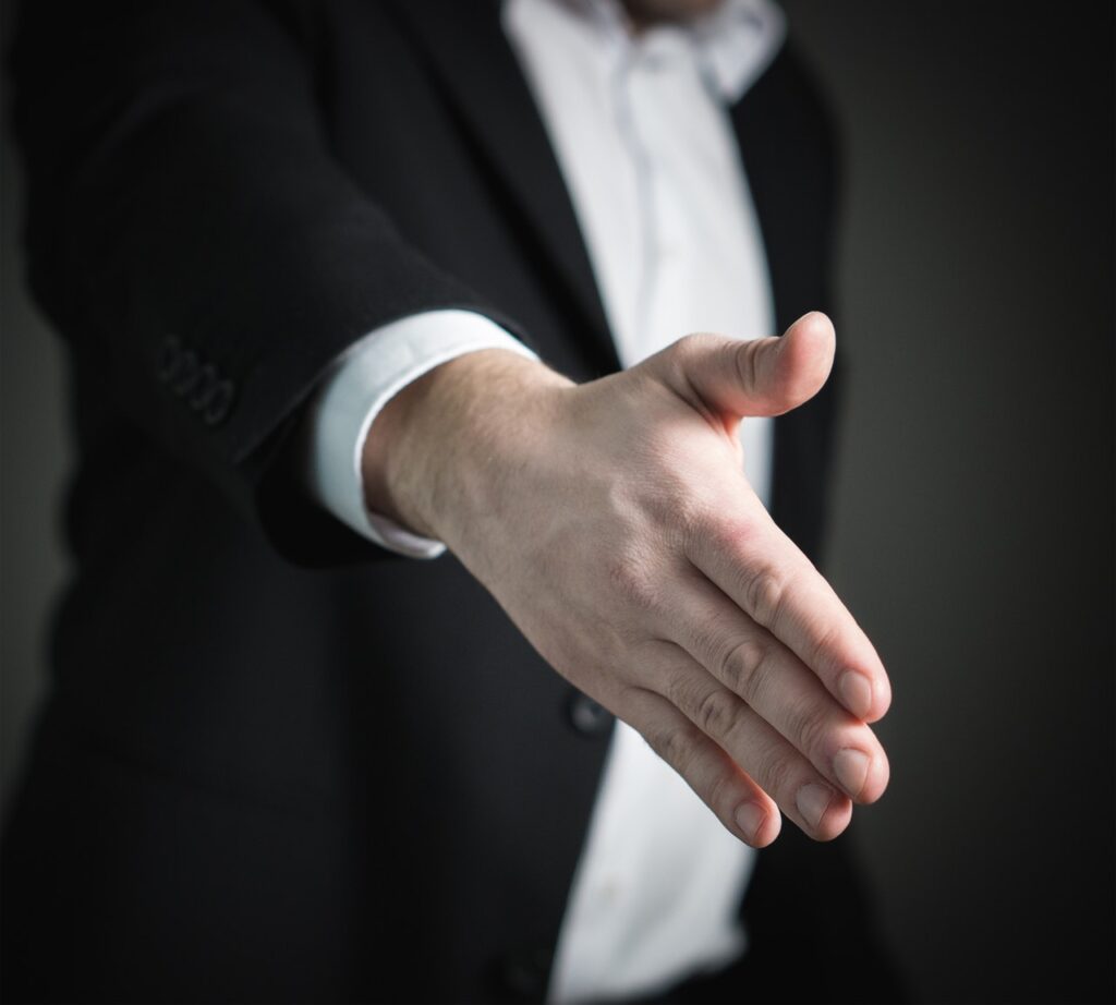 A man extending his hand to offer a handshake